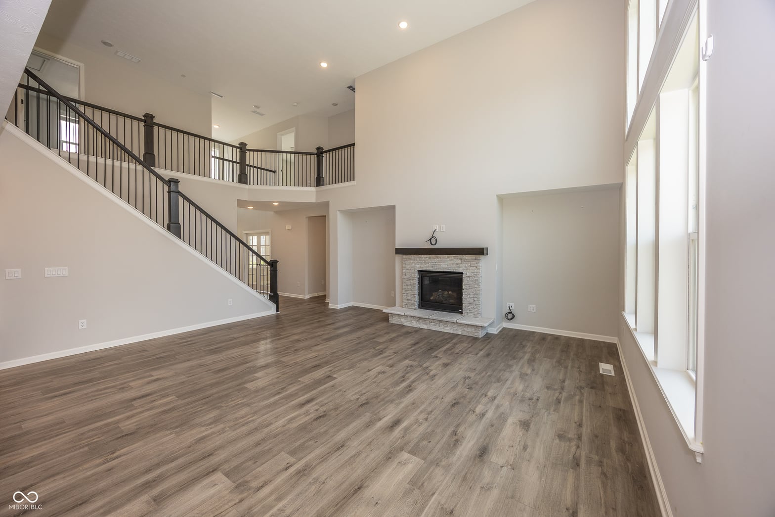 Stunning two-story family room with fireplace and natural light.