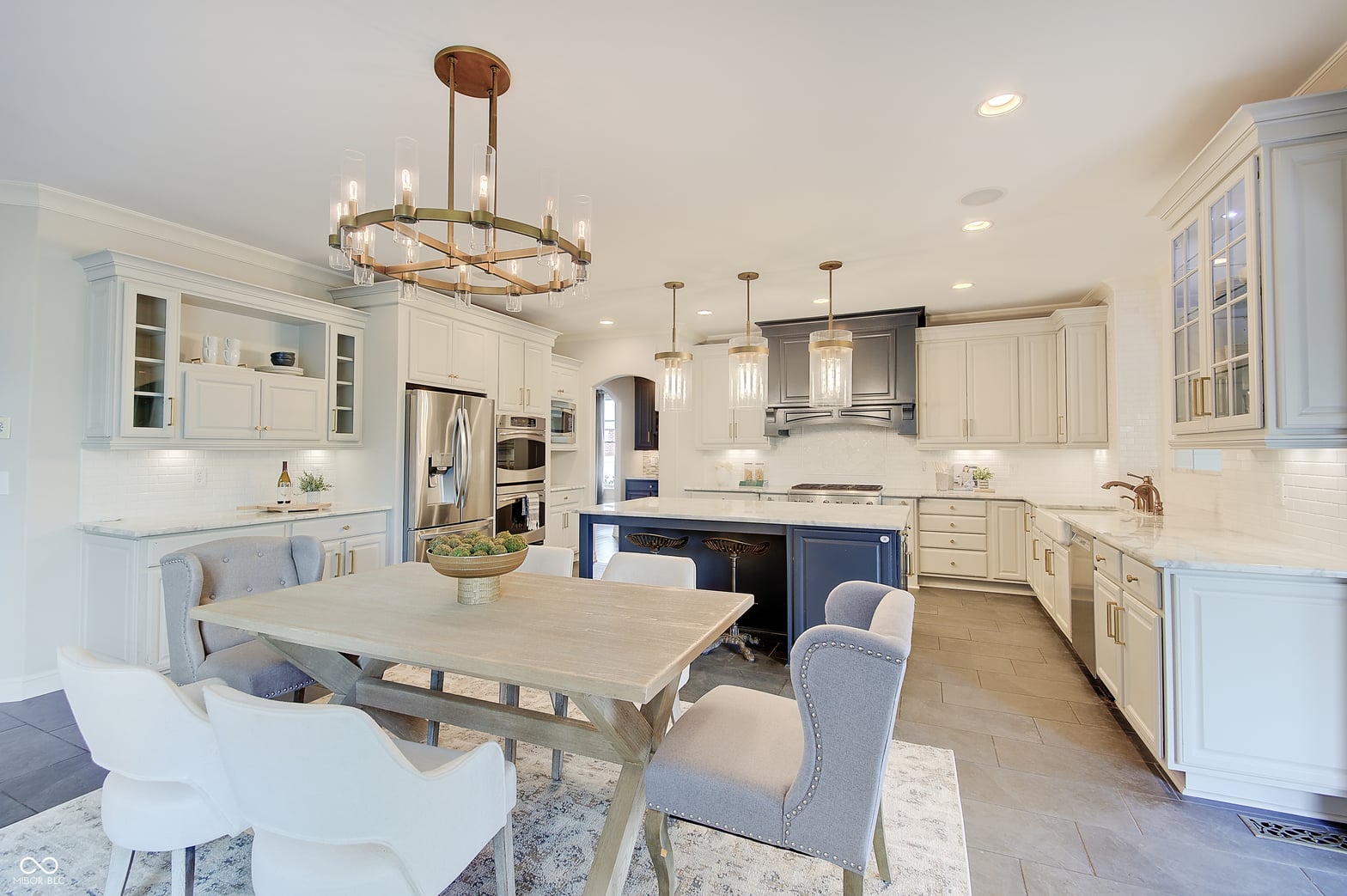 Luxe kitchen with navy island and white cabinetry.