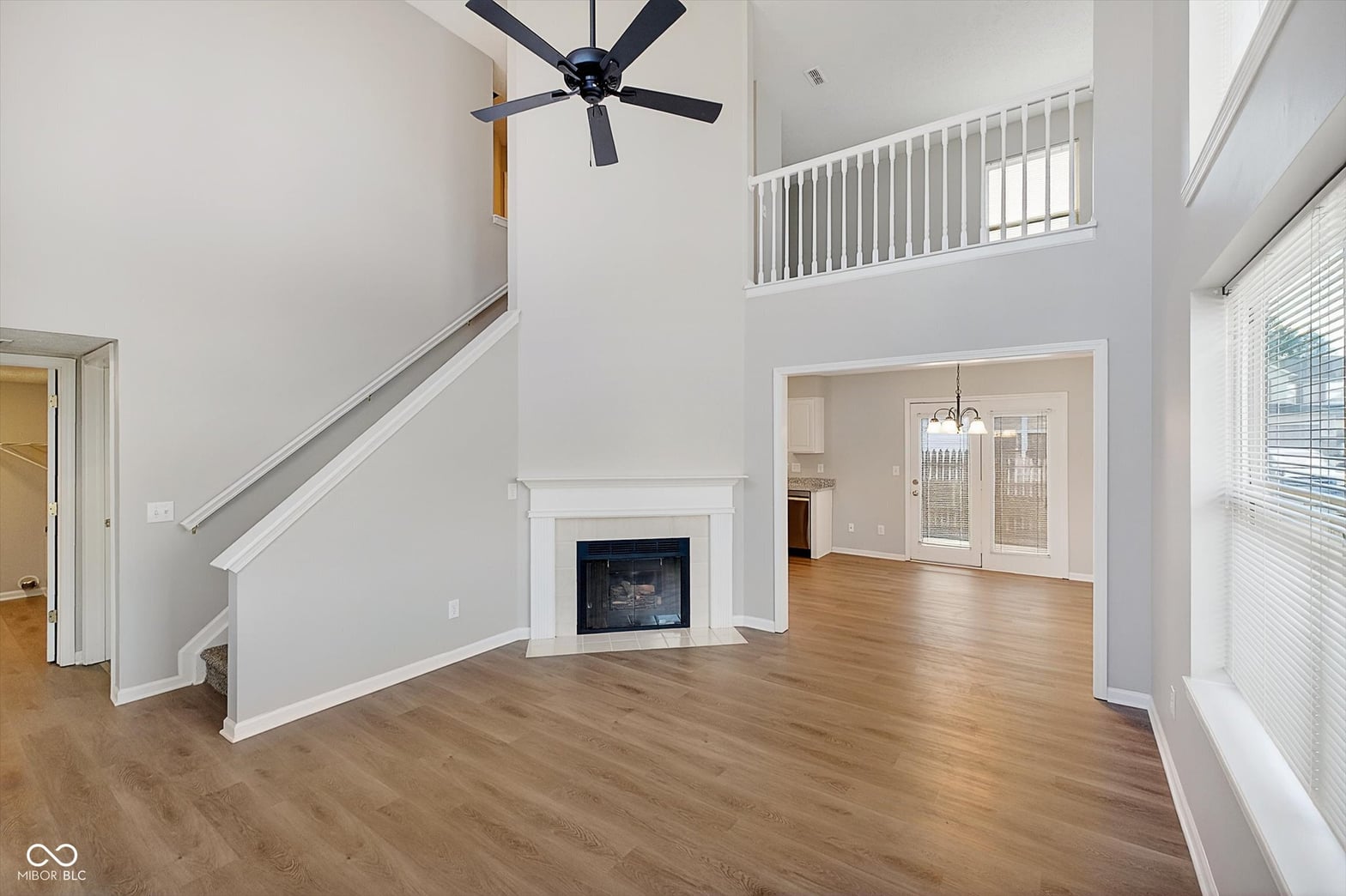 Spacious two-story family room with fireplace and hardwood floors.