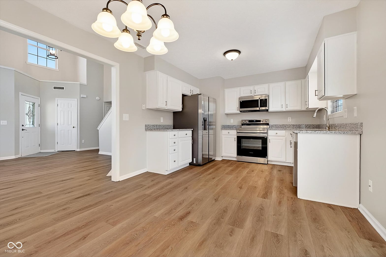 Bright kitchen with white cabinets and stainless steel appliances.