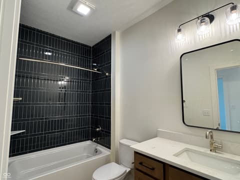 Primary bathroom at 16533 Iron Tree Court, Westfield, IN — Sleek primary bath with modern black tile shower.