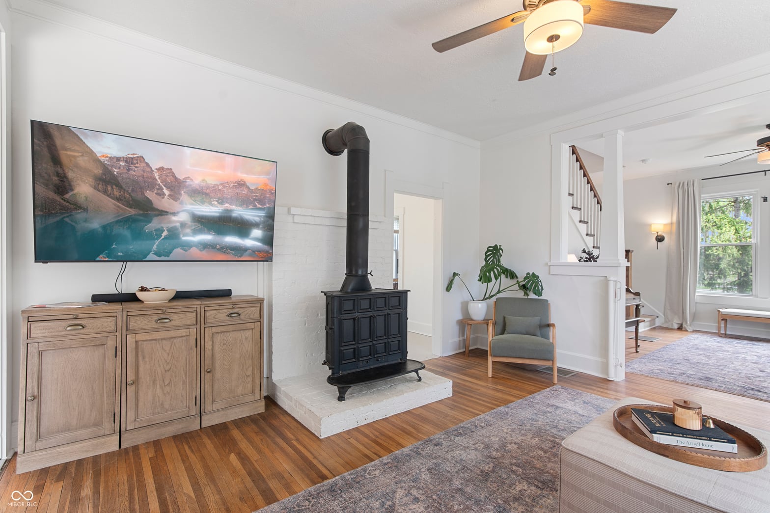 Bright living room with statement wood stove and hardwood floors.