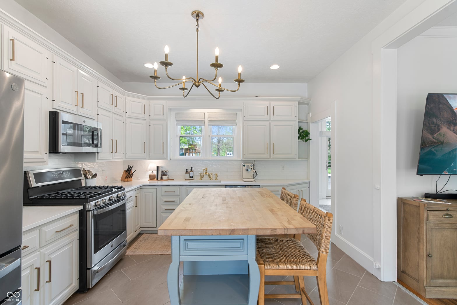Bright, updated kitchen with blue island and stainless appliances.