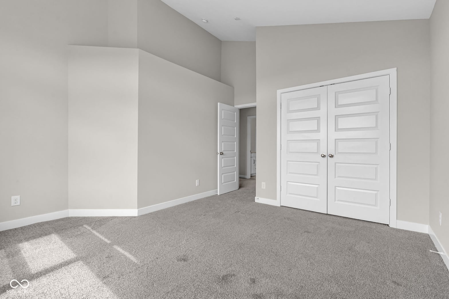 Spacious primary bedroom with double closets and vaulted ceilings.