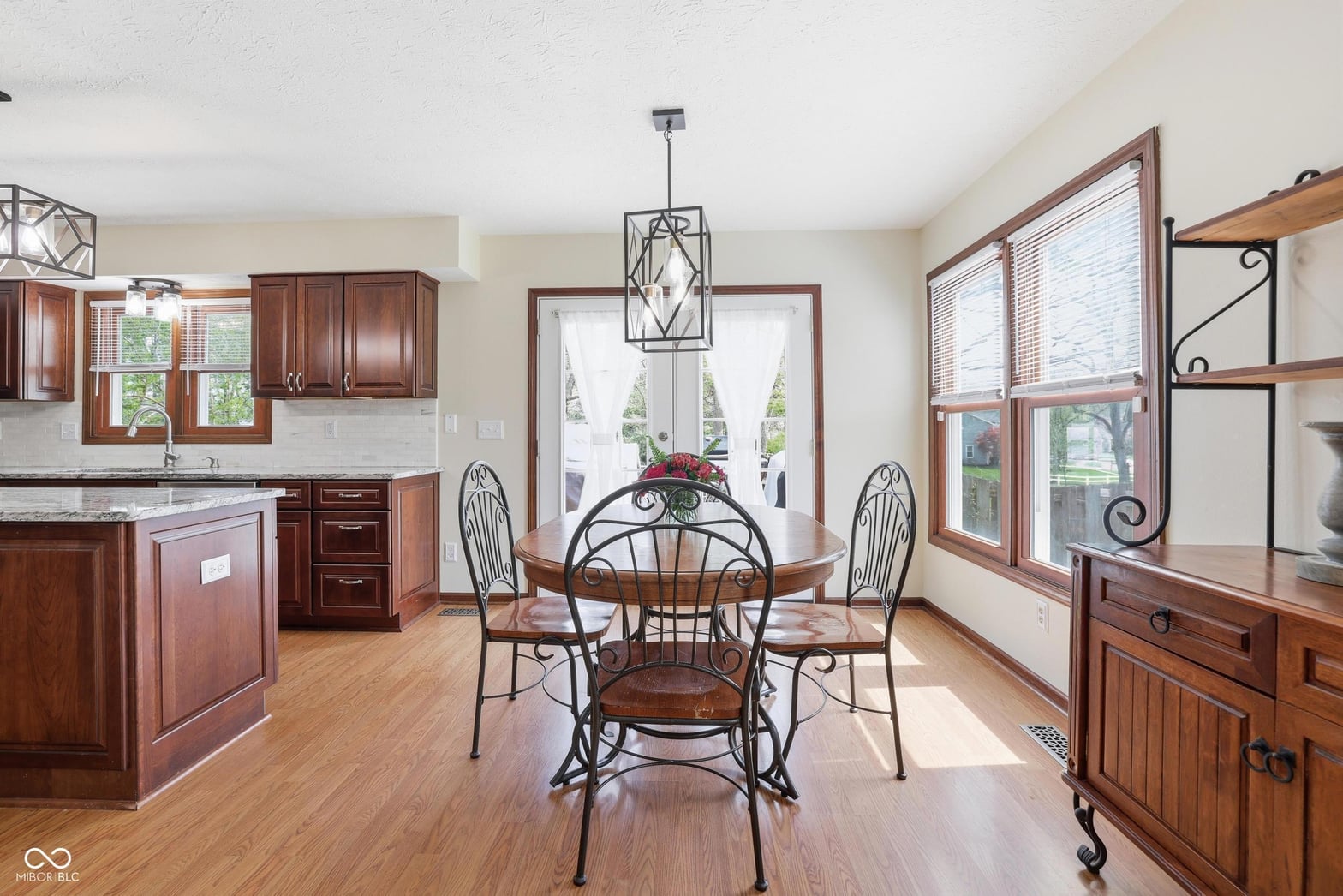 Bright kitchen-dining area with elegant wood cabinets and natural light.