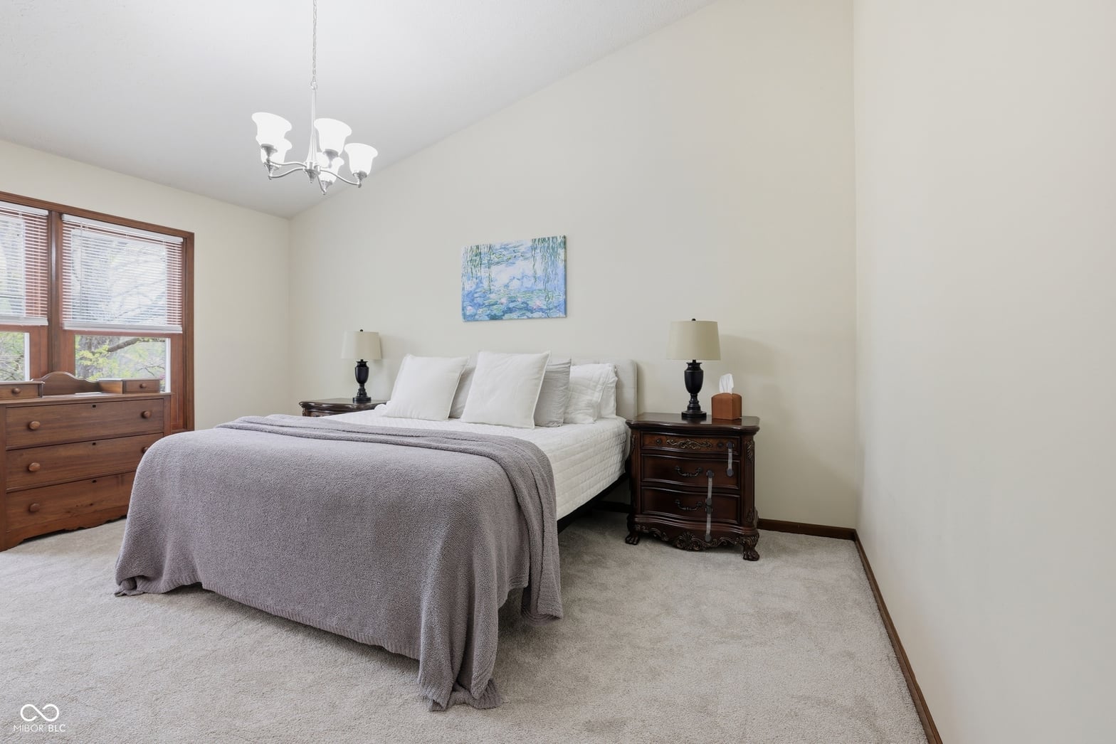 Spacious primary bedroom with classic wood furnishings and natural light.