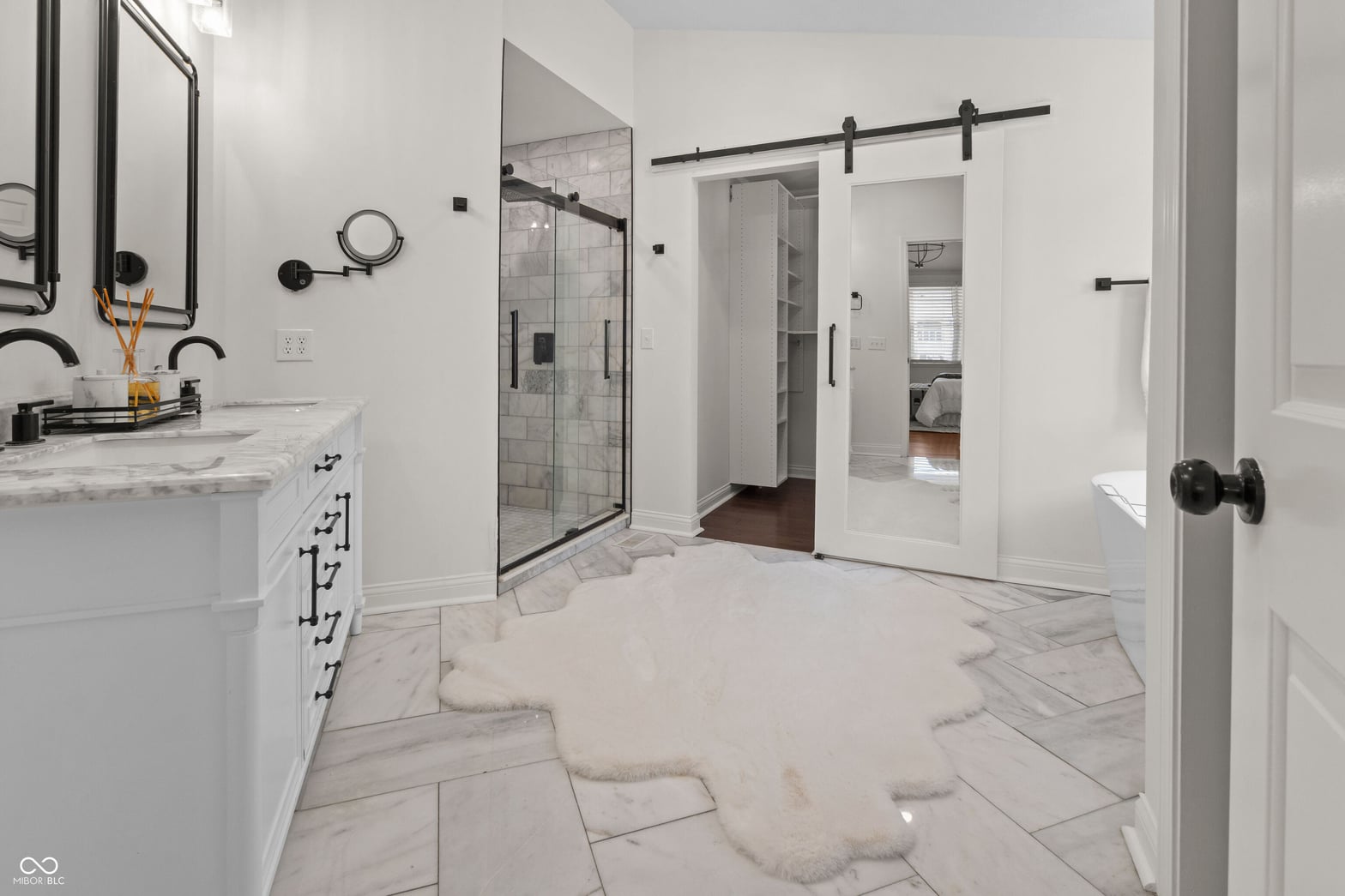 Luxurious primary bath with marble and modern finishes.