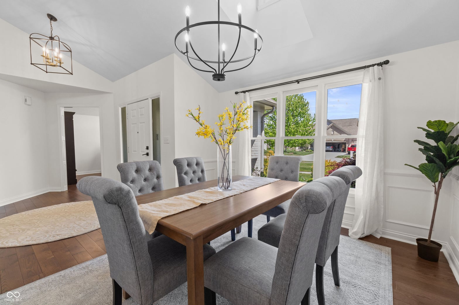 Bright dining room with French doors and vaulted ceilings.