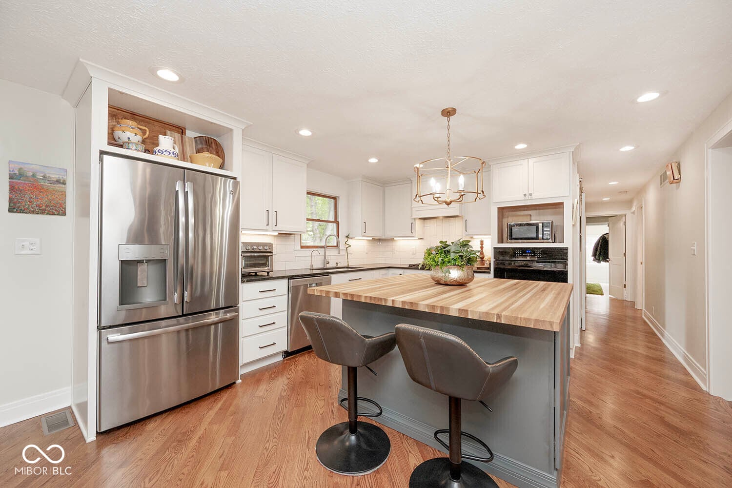 Modern renovated kitchen with island and stainless steel appliances.
