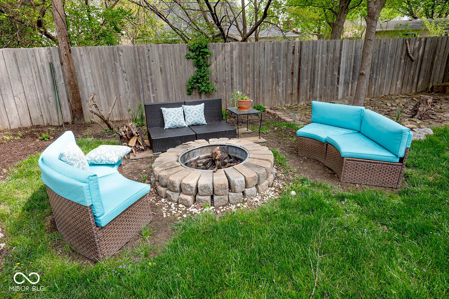 Inviting backyard oasis with stone fire pit and seating.