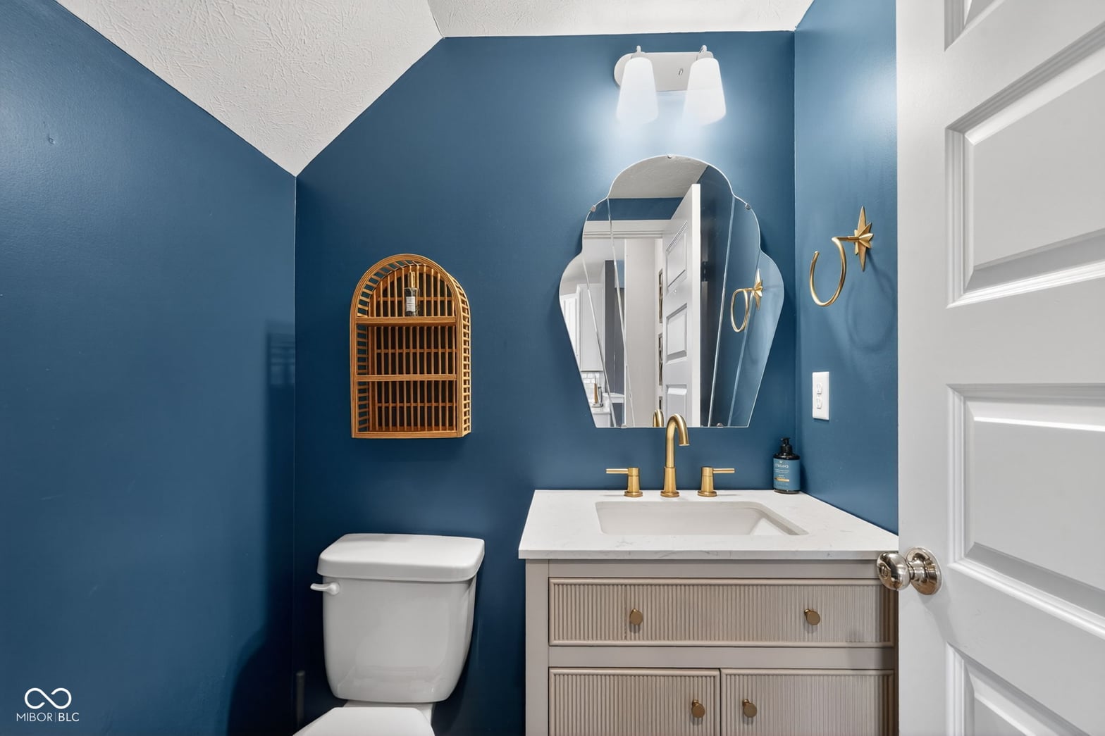 Stylish primary bath with bold blue walls and brass accents.