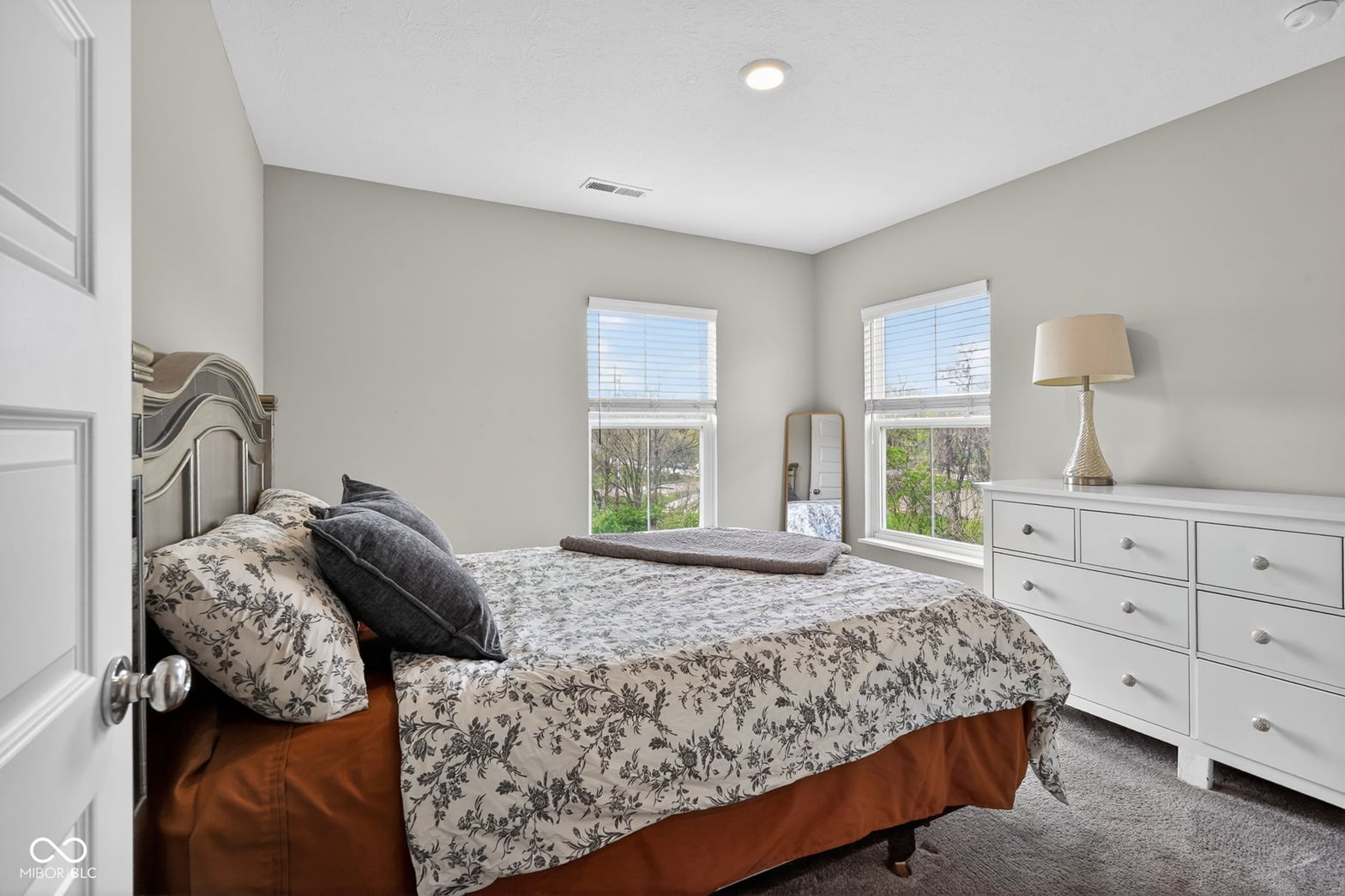 Bright primary bedroom with abundant windows and storage.