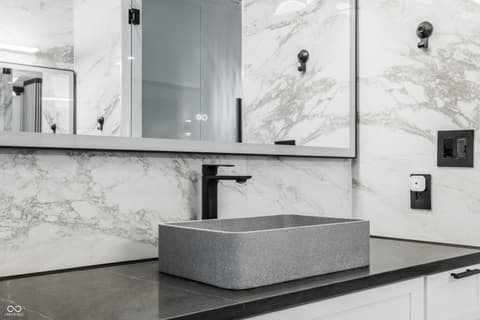 Primary bathroom at 13120 Broad Street, Carmel, IN — Luxurious modern bathroom with marble walls and vessel sink.