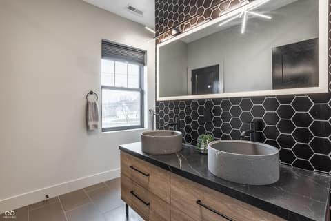 Primary bathroom at 13120 Broad Street, Carmel, IN — Luxurious modern primary bath with dual vessel sinks.