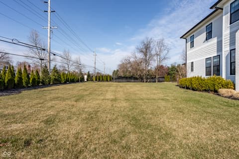 Front exterior at 13120 Broad Street, Carmel, IN — Expansive, manicured front lawn with mature landscaping.