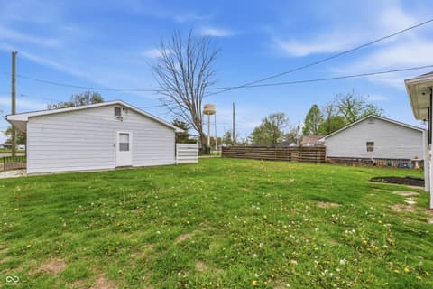 Backyard at 350 S Broadway Street, Atlanta, IN — Spacious rural backyard with outbuildings and fencing.