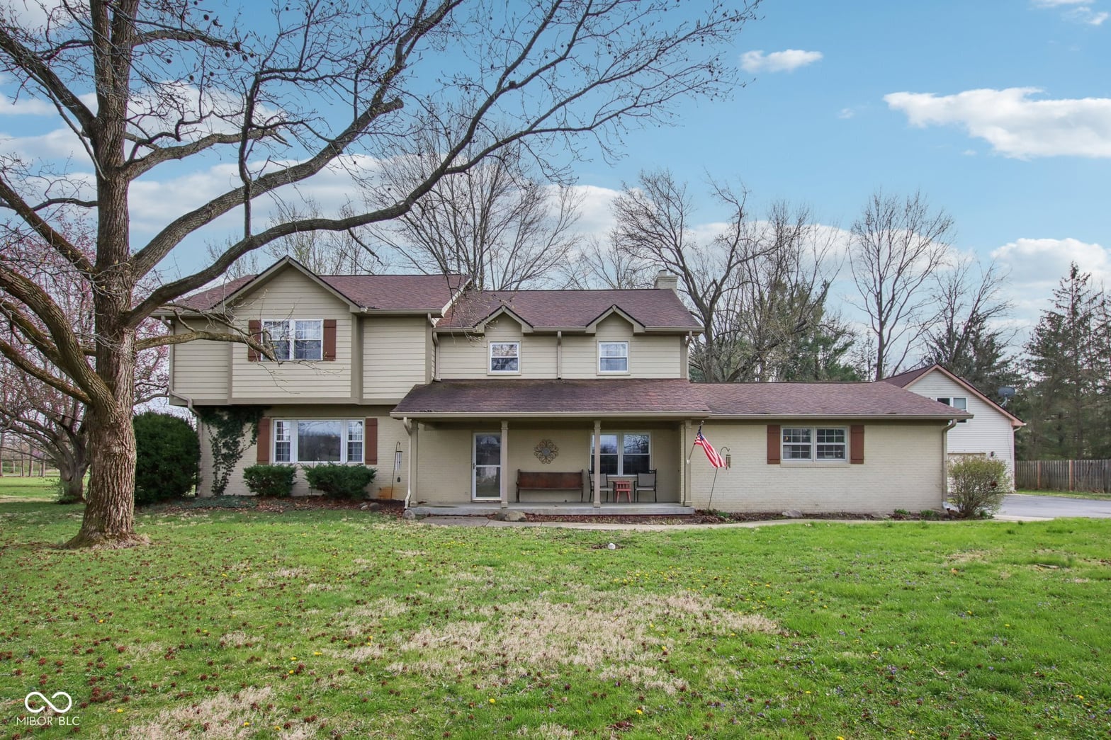 Charming two-story colonial with mature landscaping and front porch.