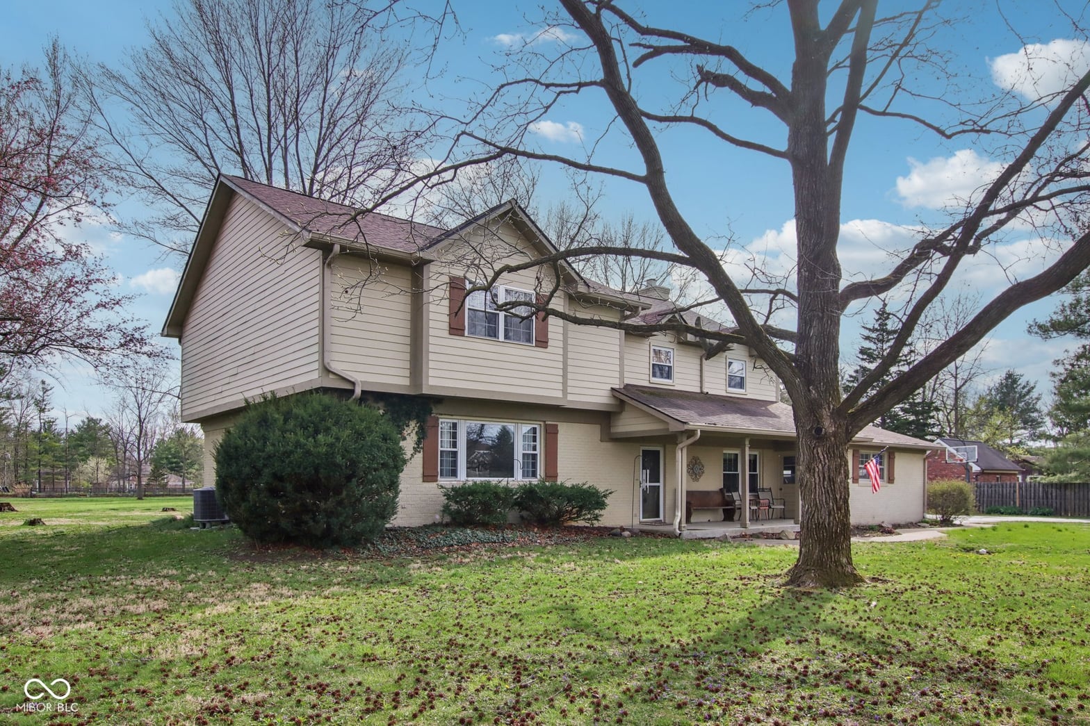 Colonial home on expansive lot with mature trees.
