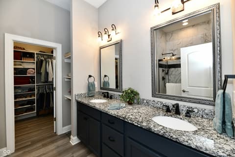 Primary bathroom at 9861 Bucklebury Lane, Carmel, IN — Luxurious primary bath with dual vanity and walk-in closet.