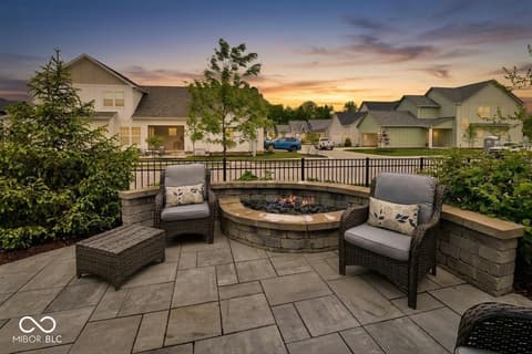 Outdoor living area at 9861 Bucklebury Lane, Carmel, IN — Stunning backyard oasis with fire pit and seating area.
