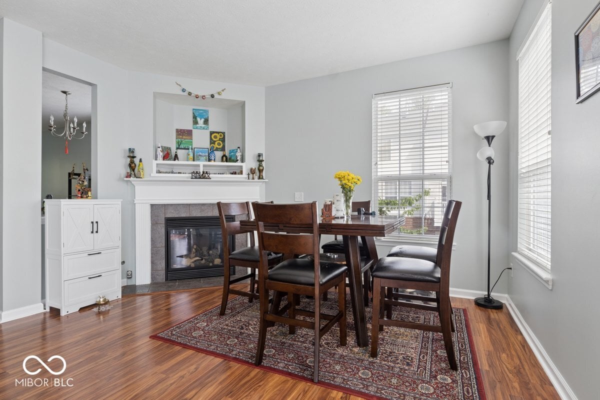 Bright dining room with fireplace and hardwood floors.