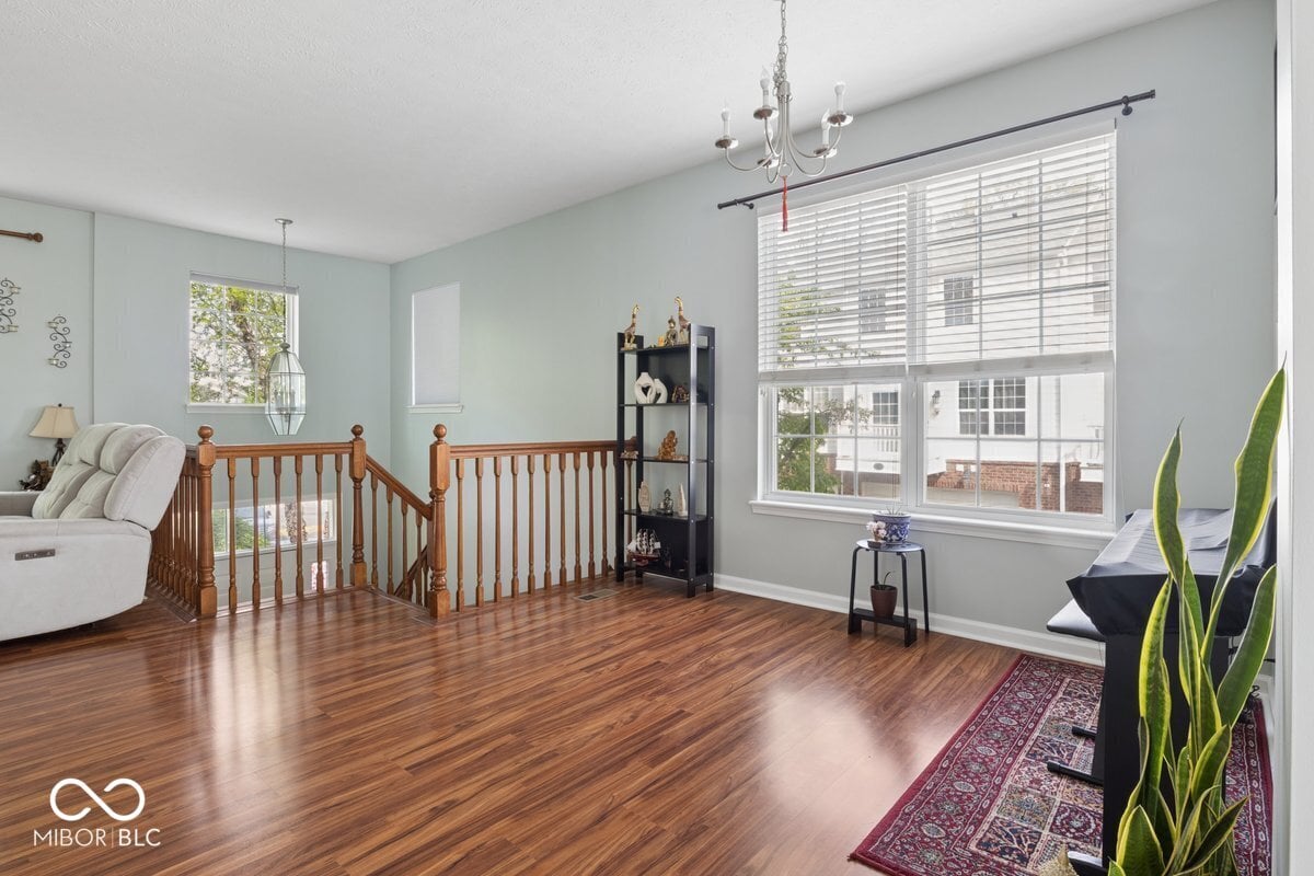 Bright primary bedroom with hardwood floors and abundant windows.