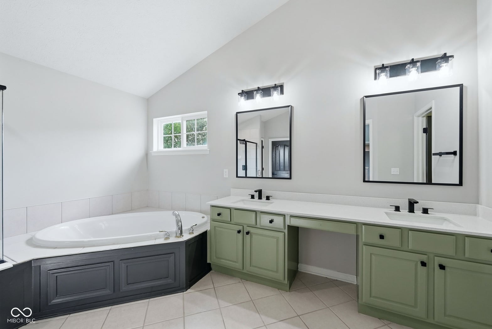 Spacious primary bath with dual vanity and soaking tub.