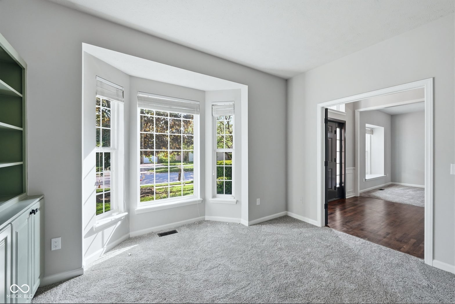 Bright family room with expansive bay windows and water views.