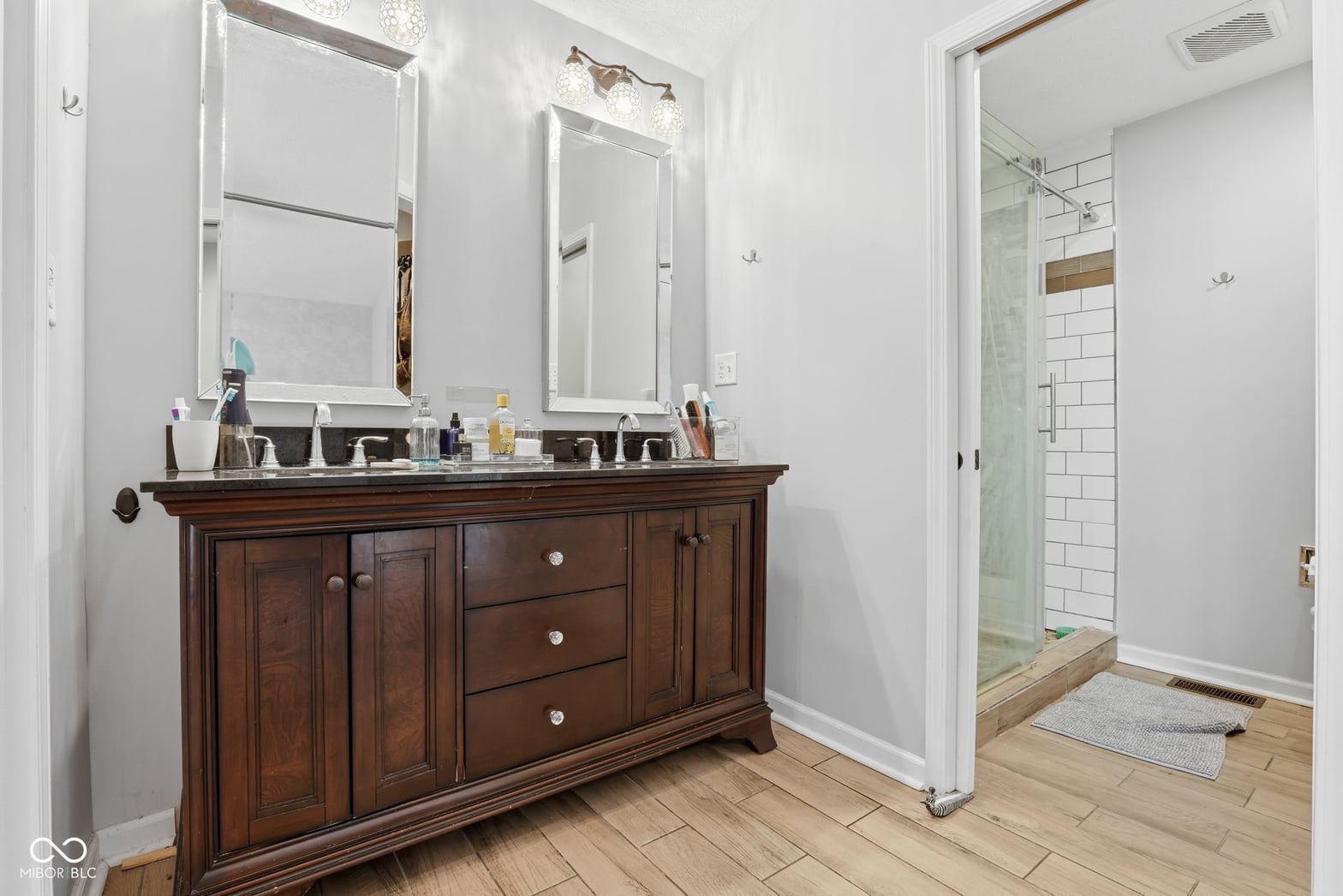 Spacious primary bath with elegant wood double vanity.