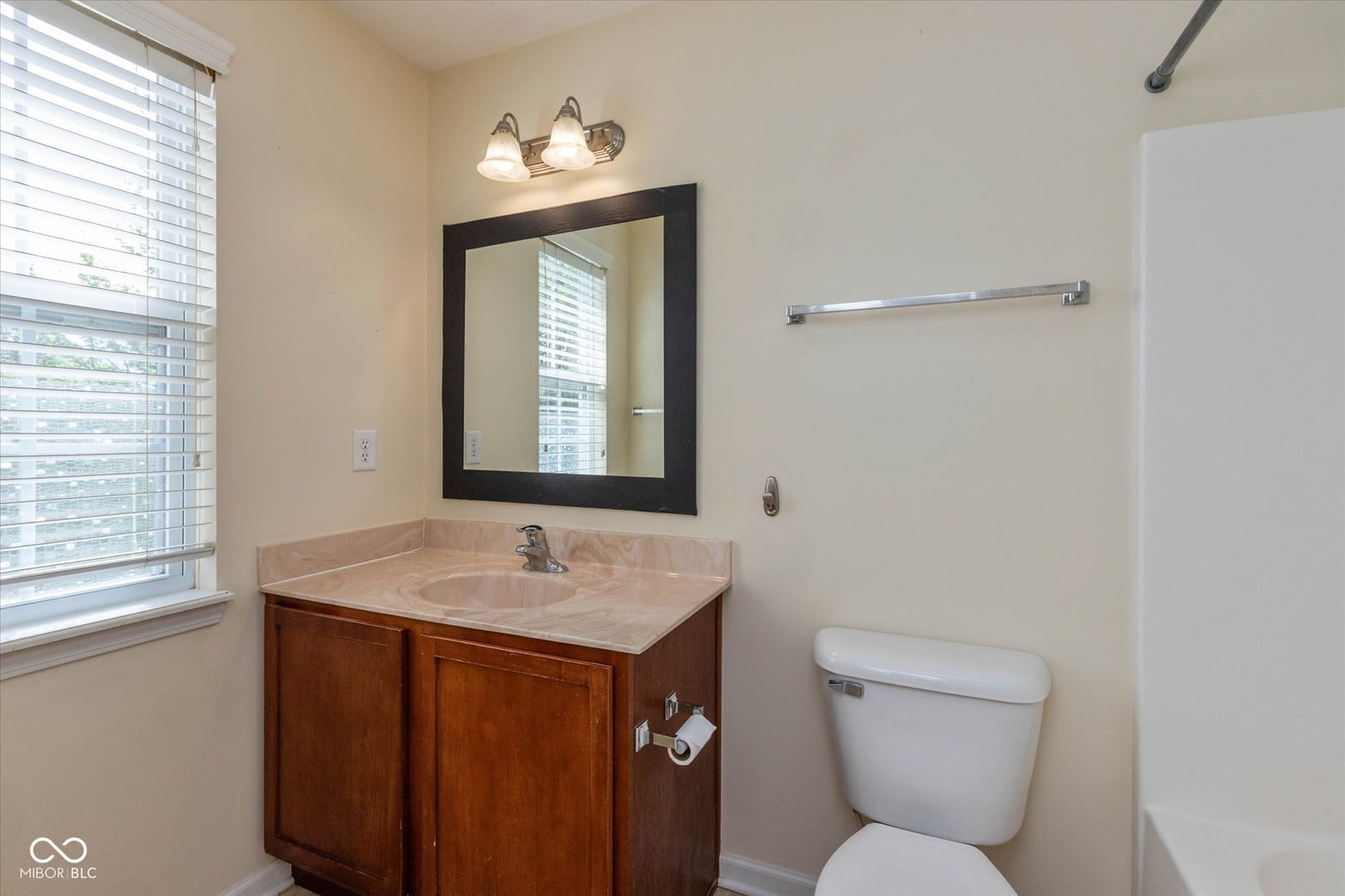 Clean, updated bathroom with marble counters and dark wood vanity.