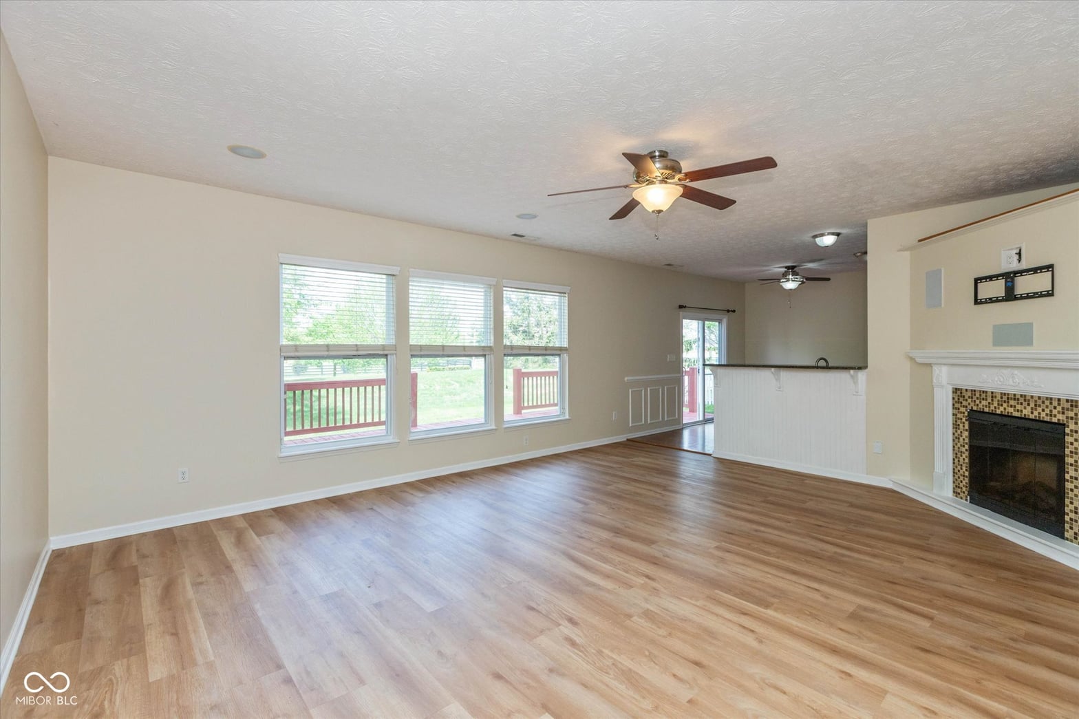 Bright family room with fireplace and expansive windows.