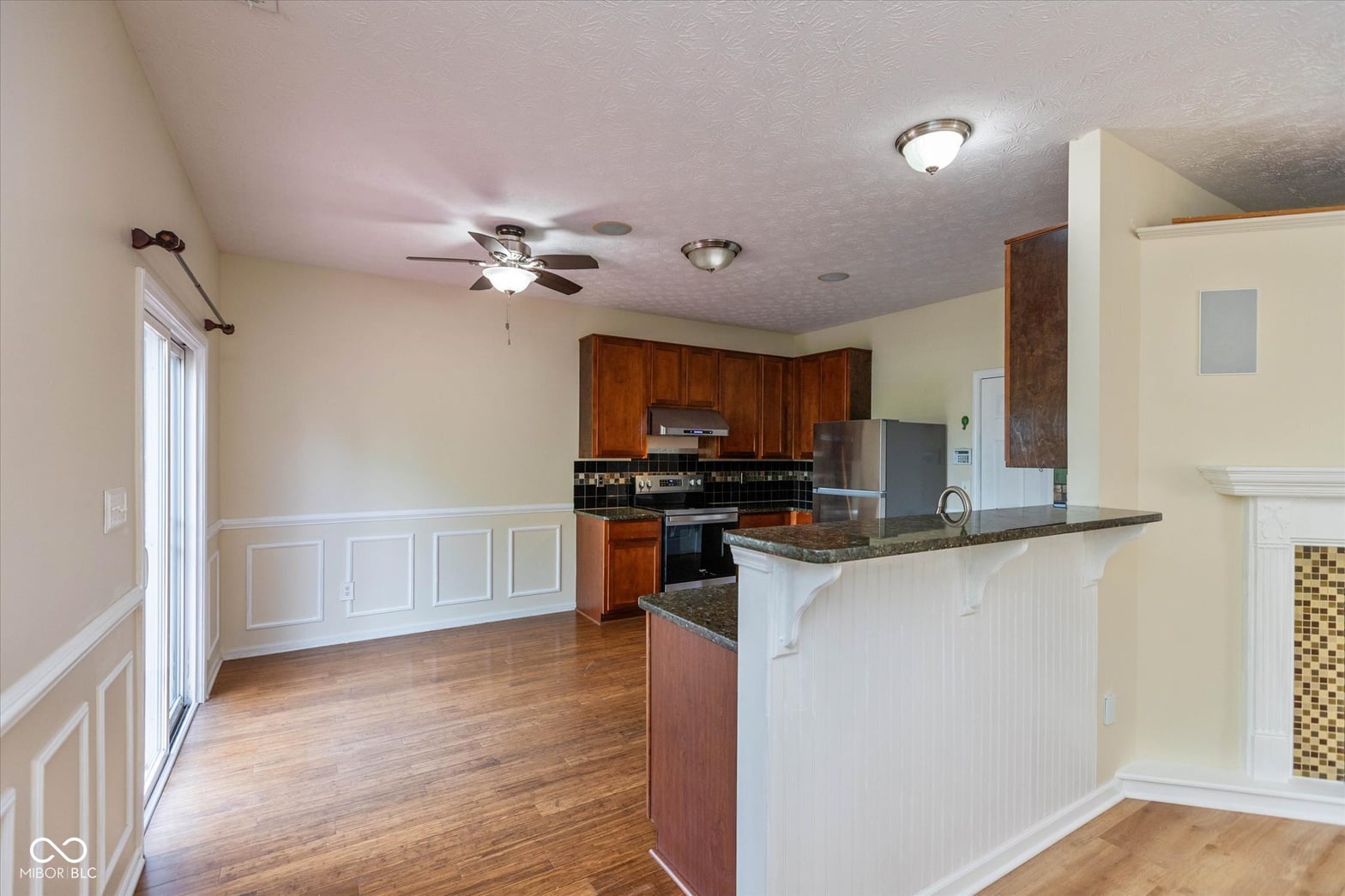 Spacious kitchen with granite counters and wood cabinetry.