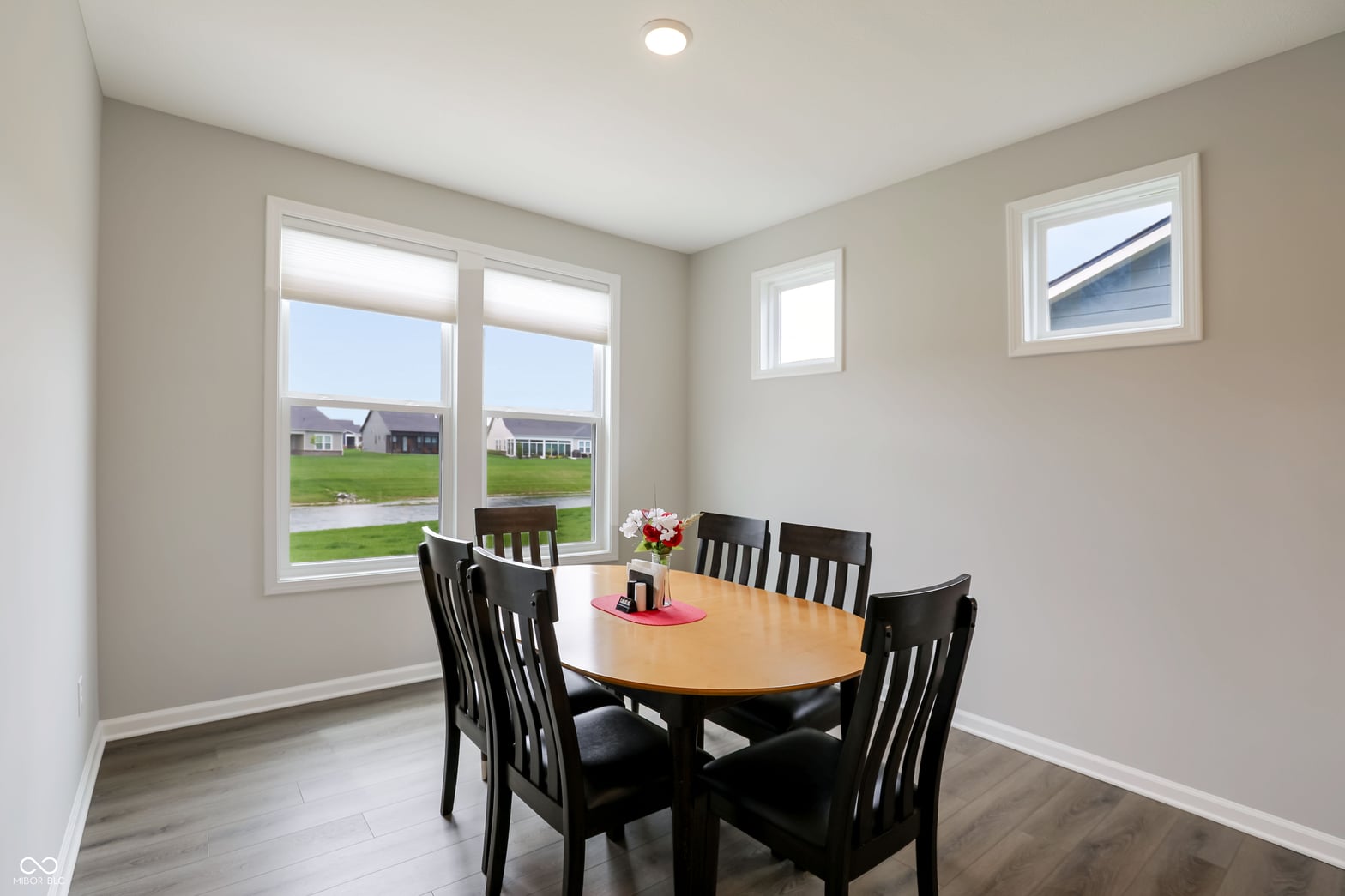 Bright dining room with expansive windows overlooking neighborhood.