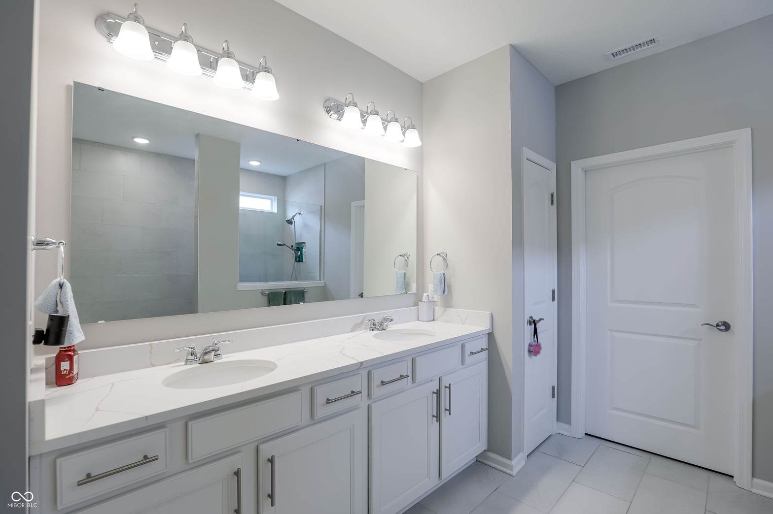 Spacious primary bath with dual vanity and modern finishes.