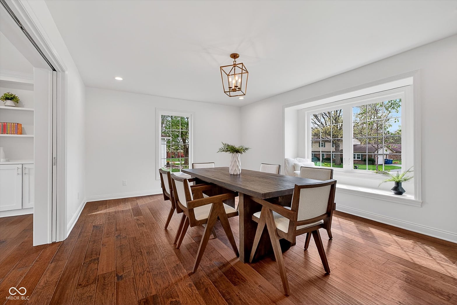 Bright dining room with mid-century modern table and abundant windows.
