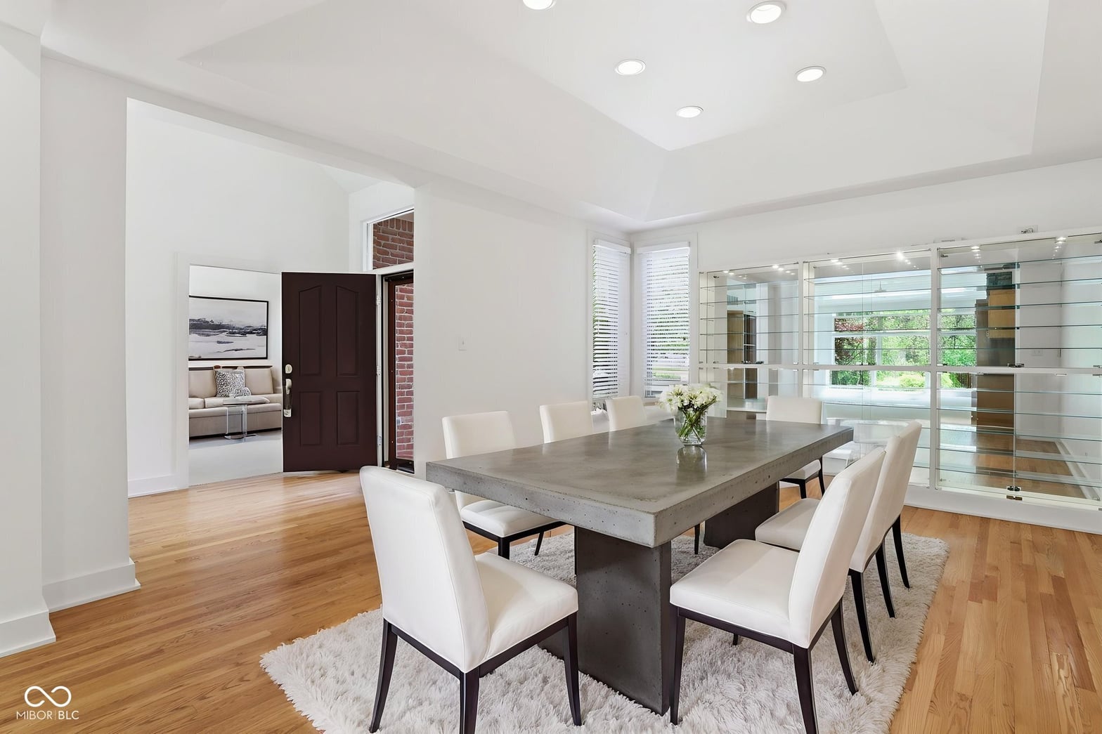 Modern dining room with concrete table and expansive windows.