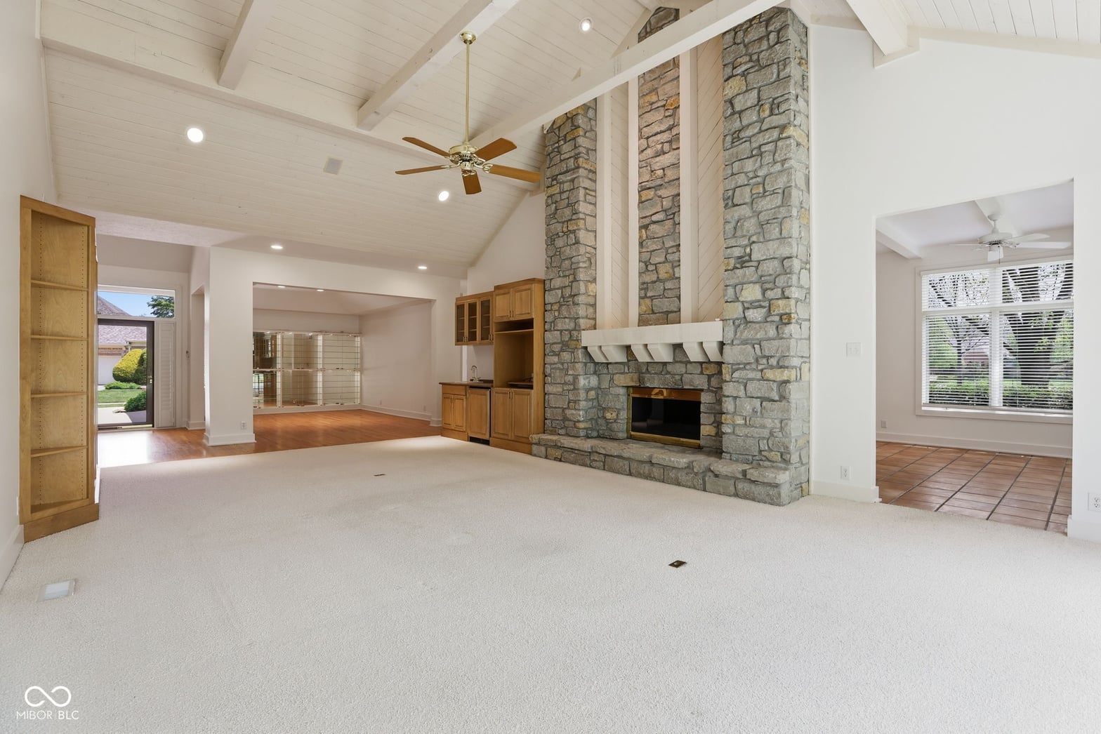 Spacious family room with dramatic stone fireplace and vaulted ceilings.