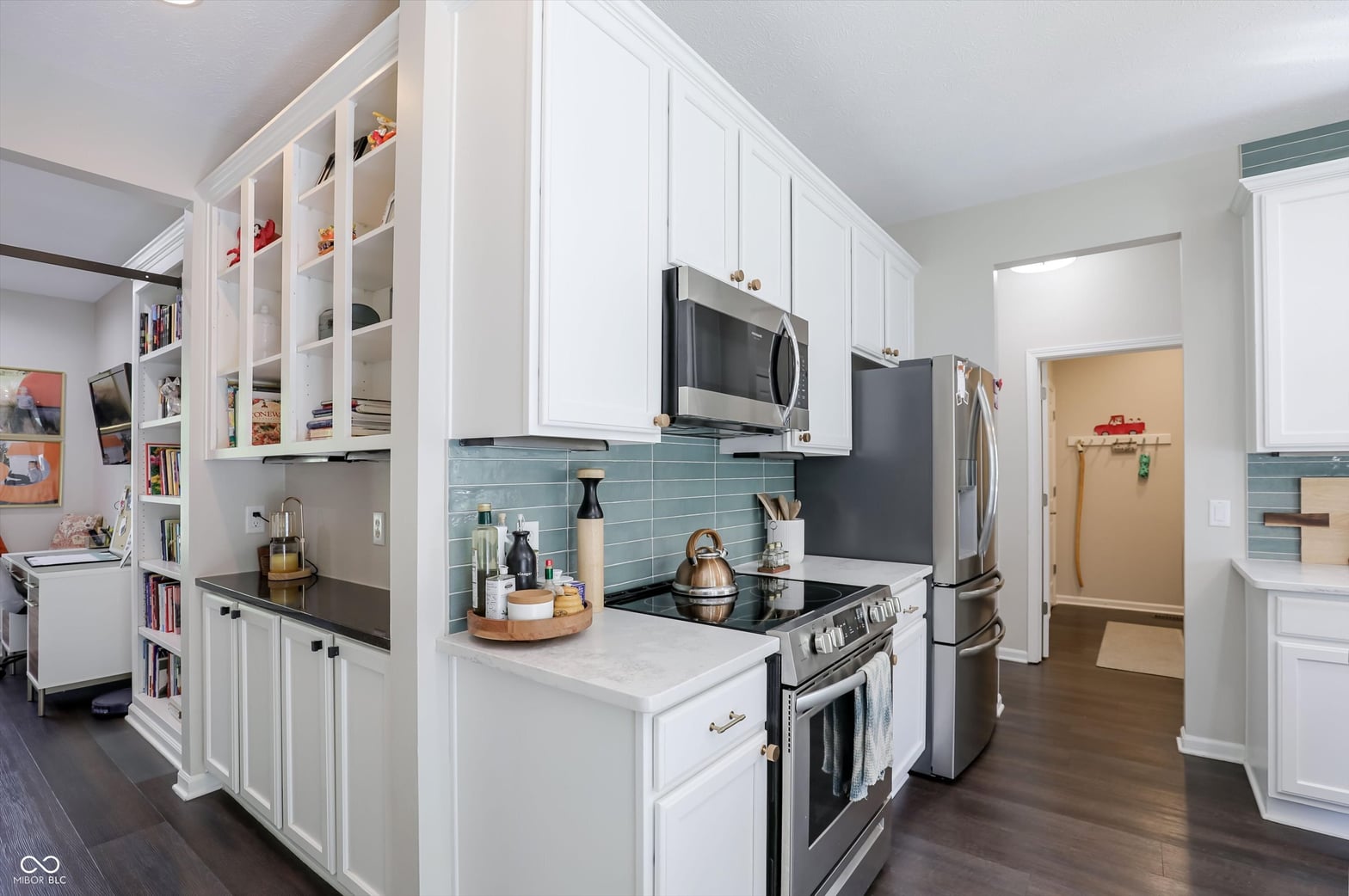 Bright contemporary kitchen with blue tile and white cabinetry.