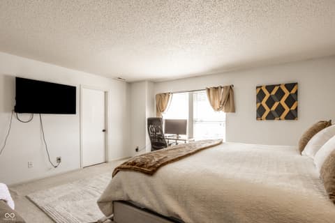 Primary bedroom at 12957 E 131st Street, Fishers, IN — Spacious primary suite with balcony access and work area.