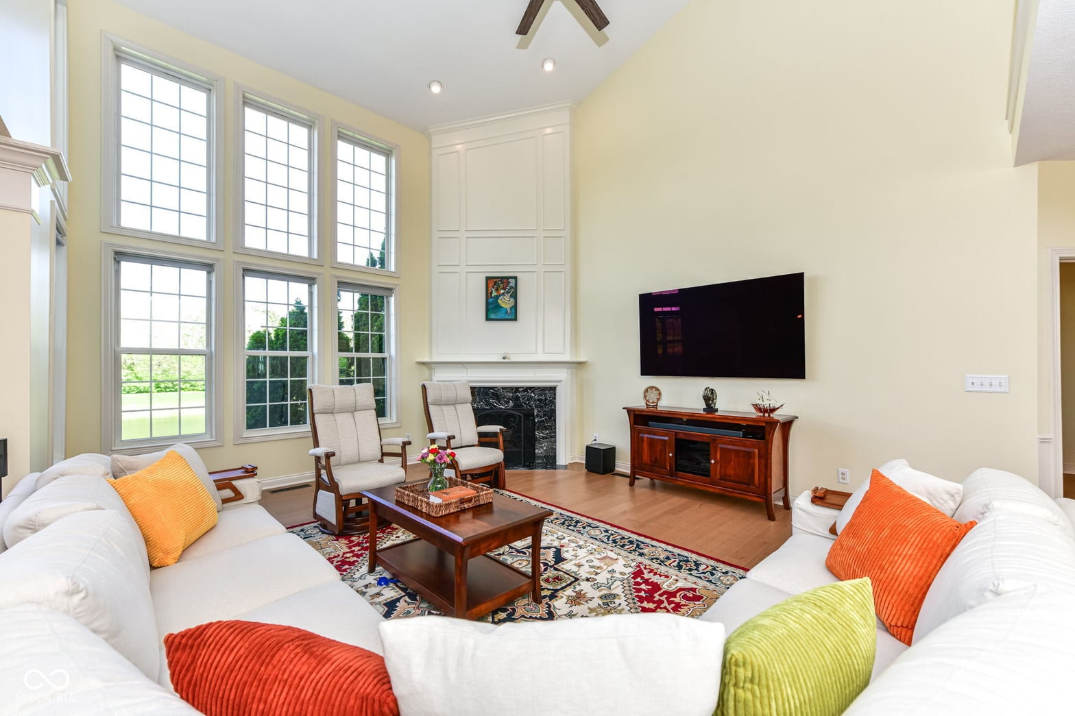 Bright living room with fireplace and expansive windows.