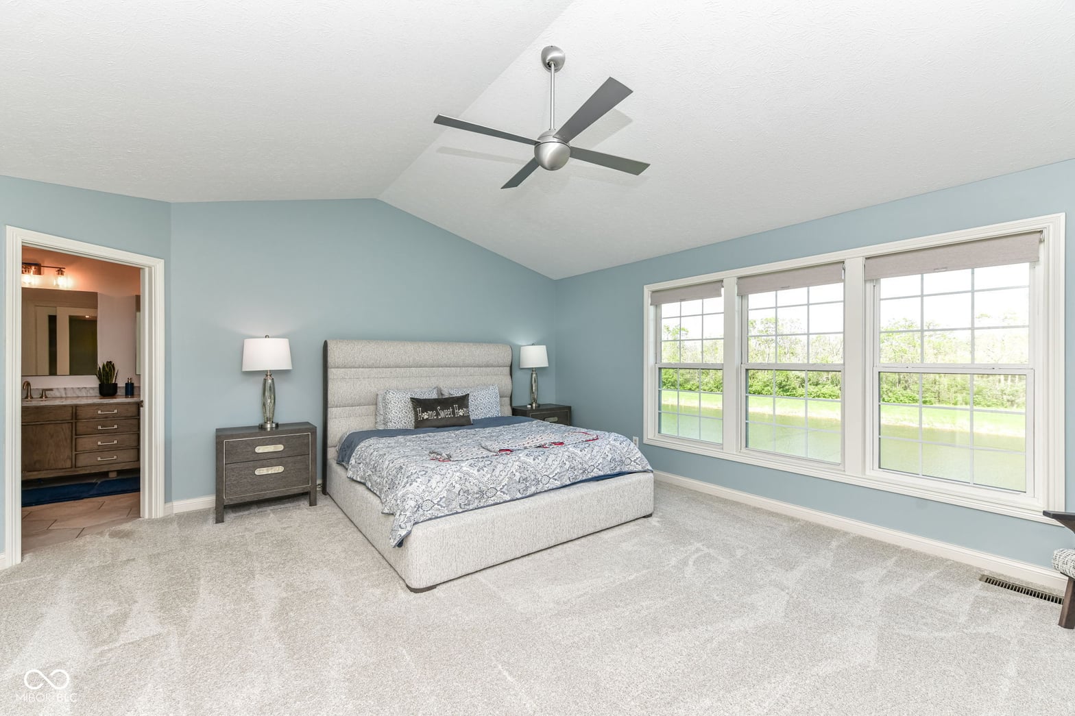 Bright primary suite with vaulted ceilings and water views.