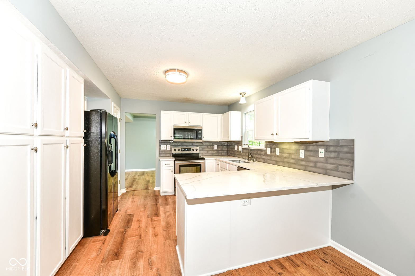 Renovated kitchen with white cabinets and modern finishes.
