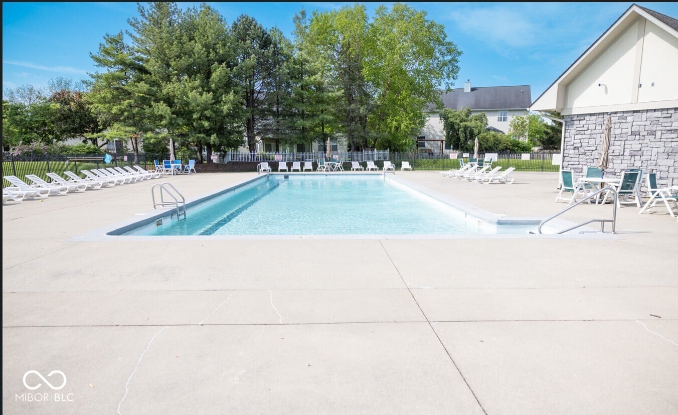Well-maintained community pool with ample seating and amenities.
