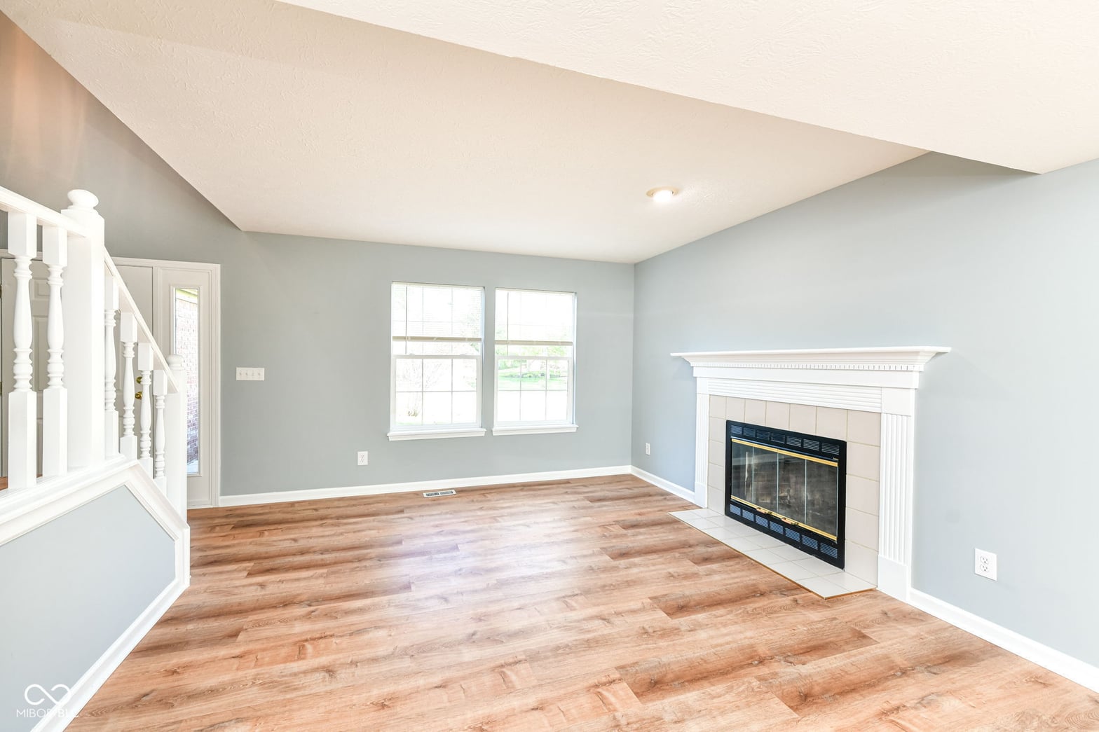 Bright, renovated family room with fireplace and hardwoods.
