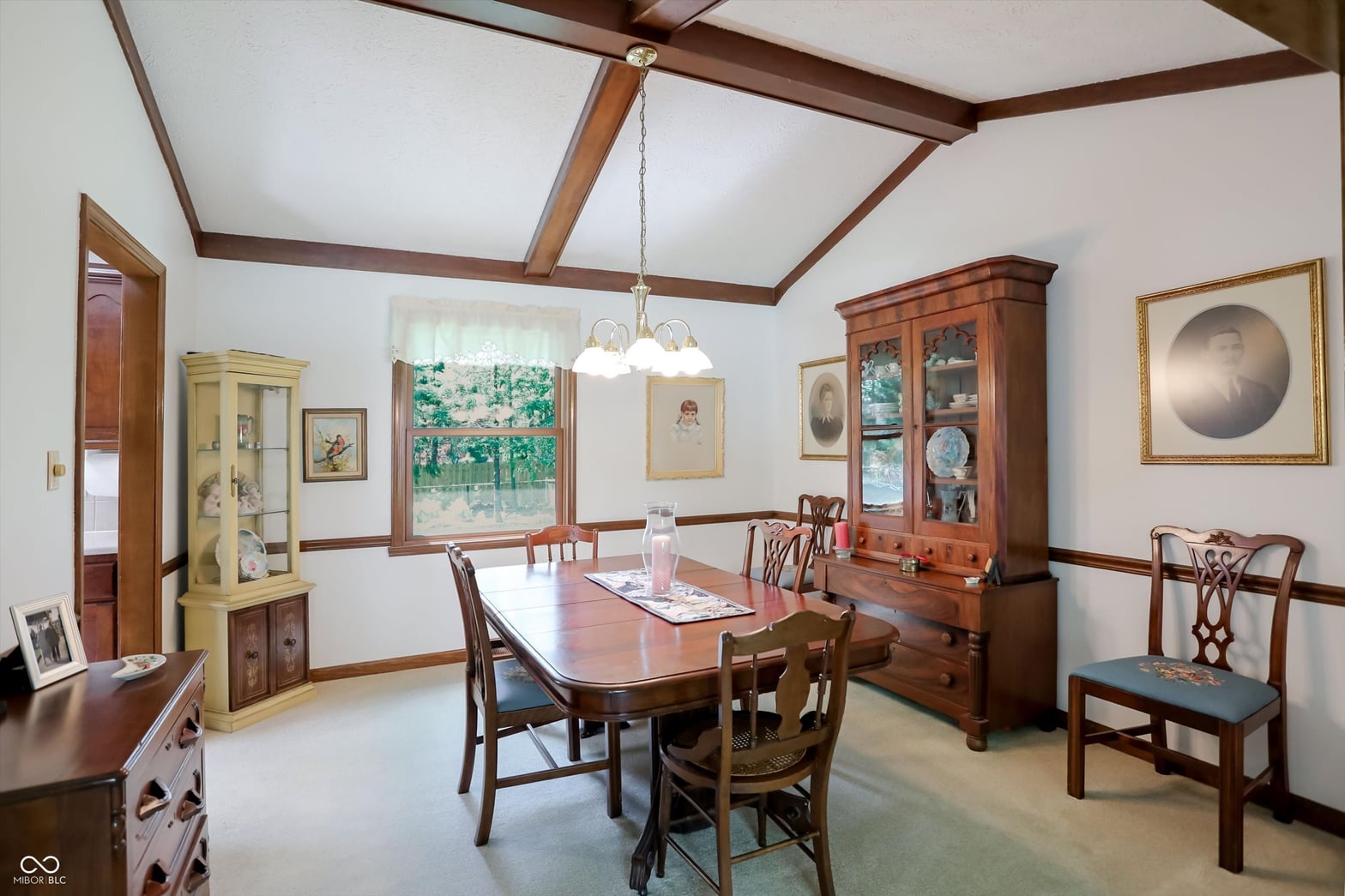 Elegant formal dining room with exposed beams and natural light.