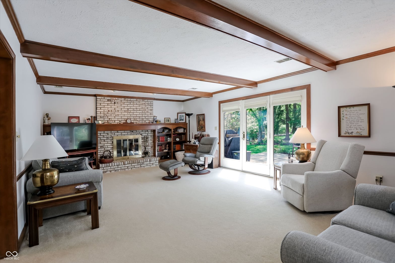 Spacious family room with exposed beams and brick fireplace.