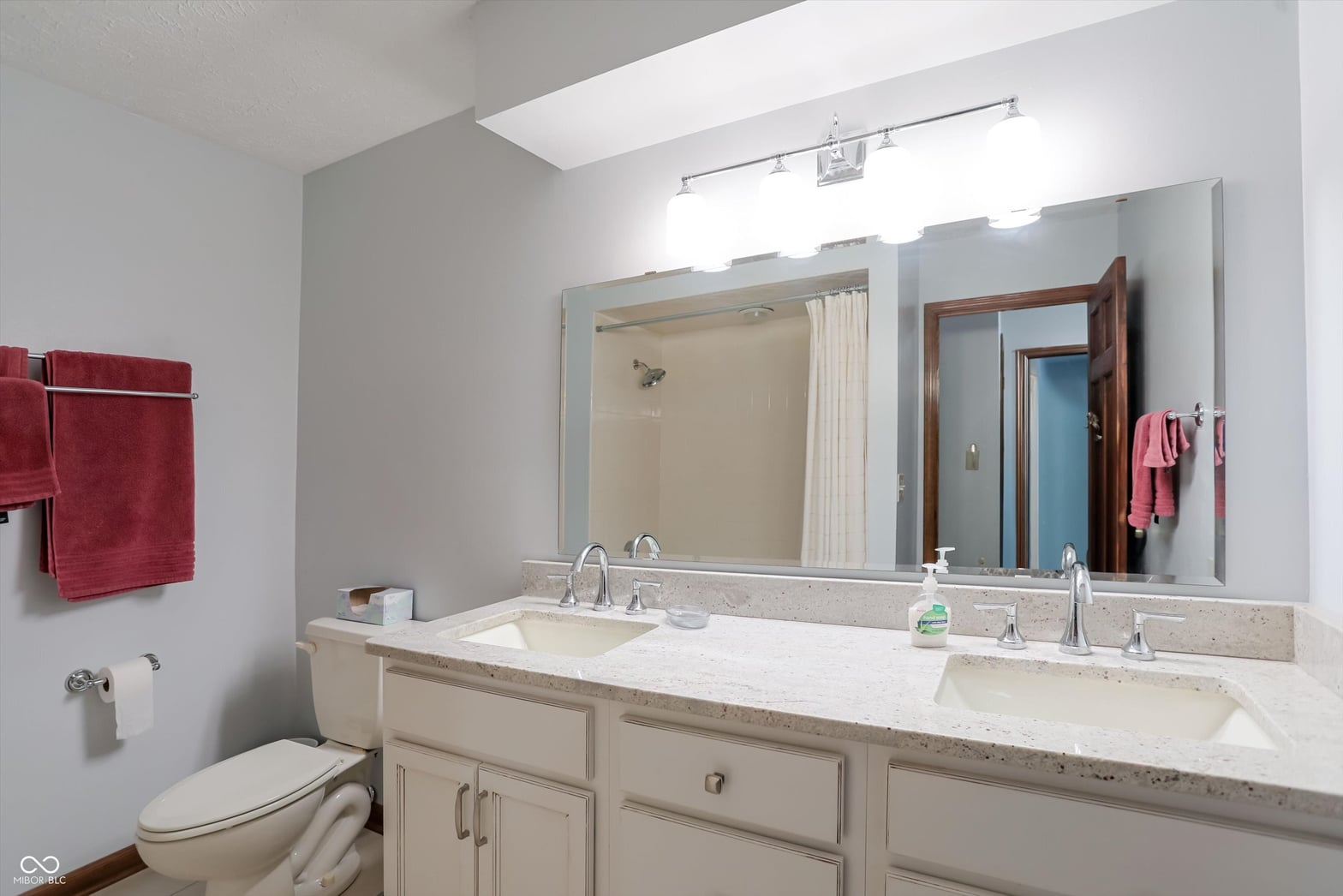 Bright primary bath with dual vanity and skylight.