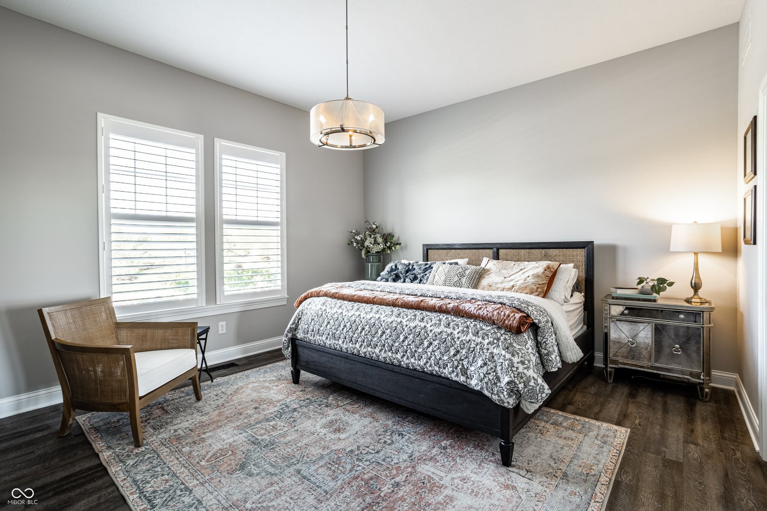Bright primary bedroom with modern shutters and elegant lighting.