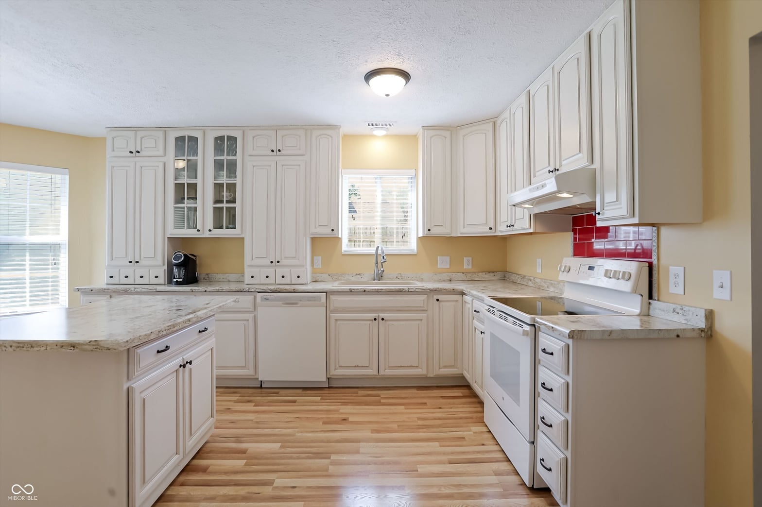 Bright, updated kitchen with white cabinetry and granite counters.