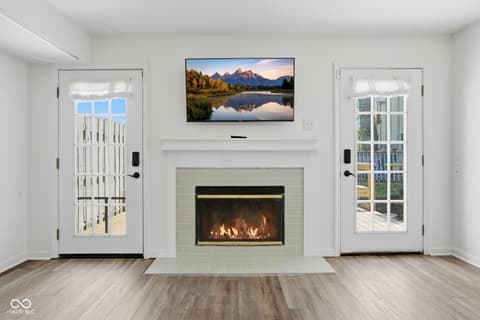 Living room at 6048 S Bay Drive, Indianapolis, IN — Modern living room with gas fireplace and French doors.